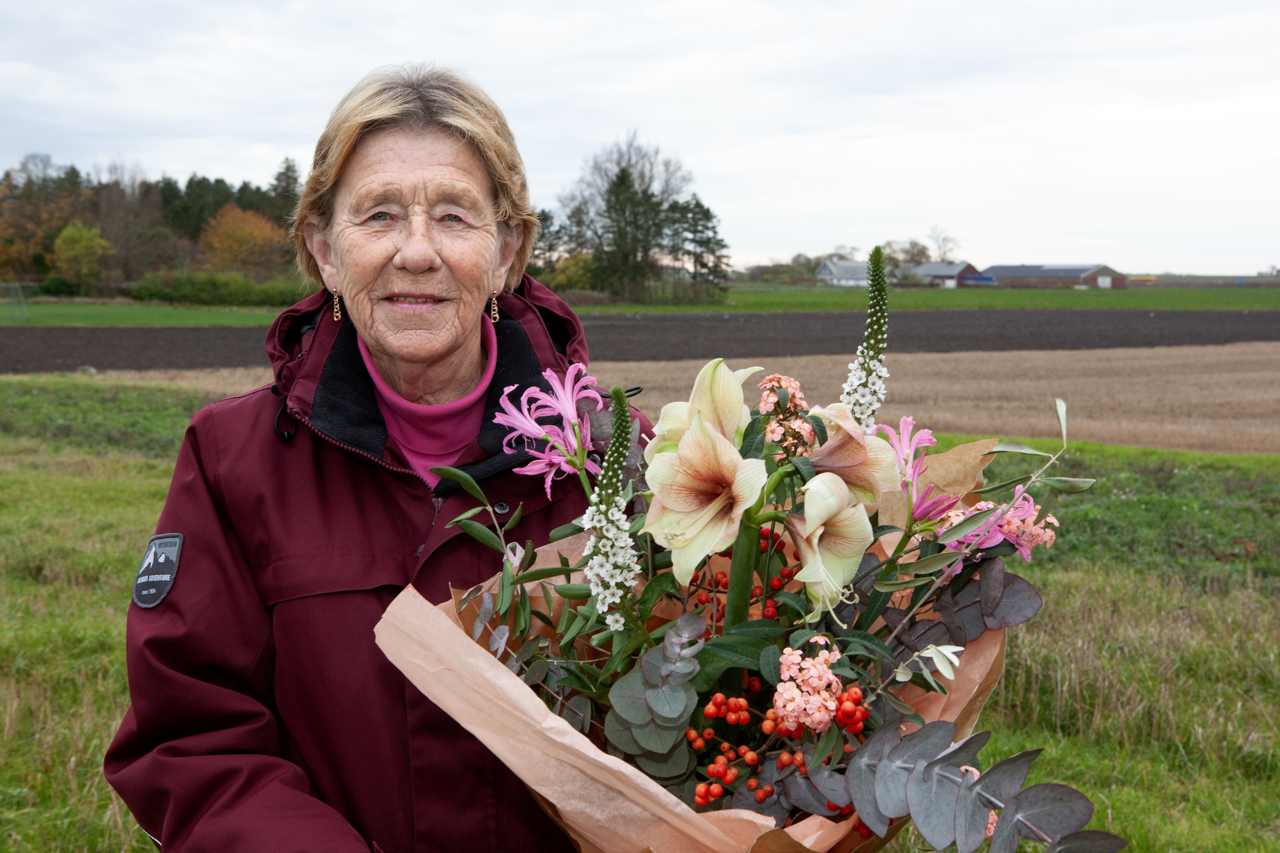 En glad vinnare med blombukett